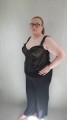 Czarny gorset z szyfonu zdobionego czarnymi, aksamitnymi motywami roślinnymi, przedstawiony na modelce PLUS SIZE. Fantazyjne skrzydełka na biodrach sprawiają, że figura jeszcze bardziej przypomina klepsydrę.